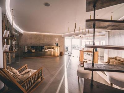 Chambre d'hôtel moderne et ouverte avec meubles en bois, grande baie vitrée et ambiance loft.