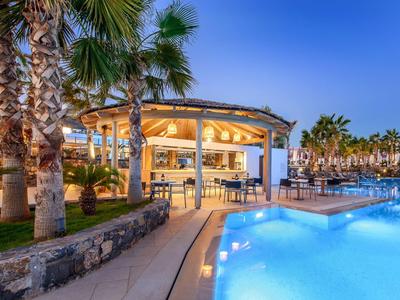 Beleuchteter Poolbereich mit Palmen, offenem Pavillon und gemütlicher Abendatmosphäre.