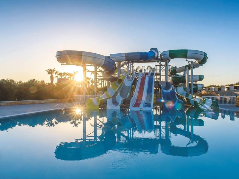 Toboggans aquatiques dans la piscine d'un hôtel au coucher du soleil