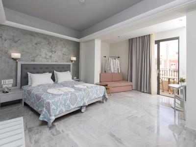 Camera d'hotel luminosa con letto matrimoniale, poltrona e balcone