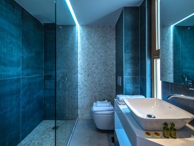 Moderne badkamer met donkergrijze tegels, vrijstaand wasbakje en aparte douche.