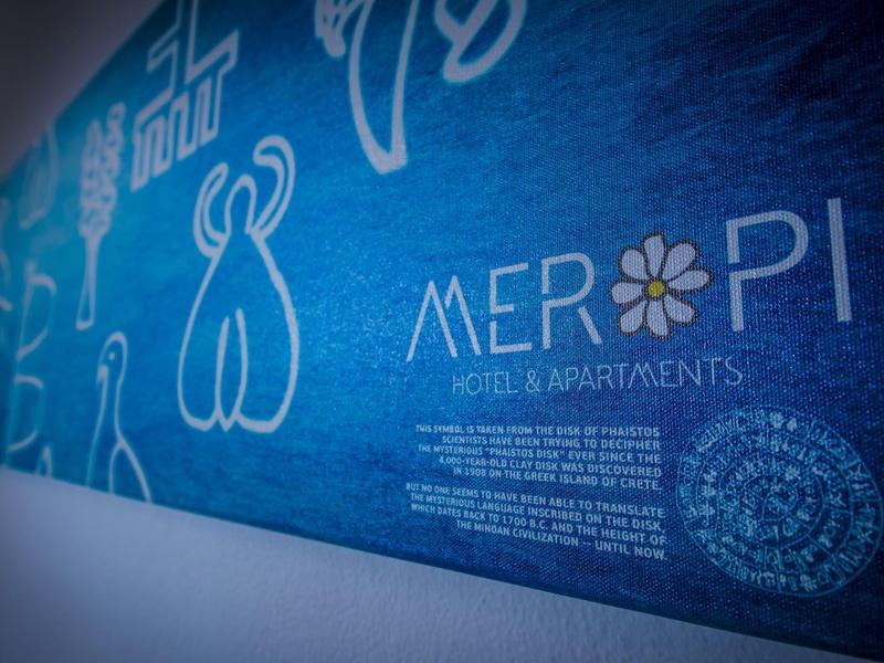 Blauw reclamebord voor Meropi Hotel & Apartments met witte symbolen en tekst.