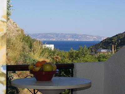 Blick auf das Meer mit Früchteschale auf einem Tisch auf einer Terrasse.