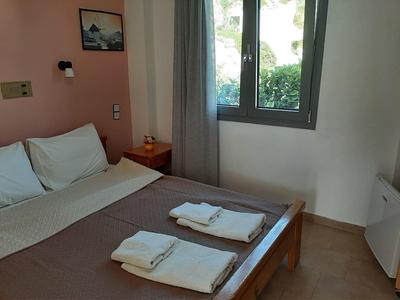 Gemütliches Hotelzimmer mit Doppelbett, zwei Handtüchern und Blick aus dem Fenster.