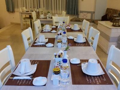 Schlicht gedeckter Esstisch mit weißem Geschirr und Stühlen in einem modernen Esszimmer.