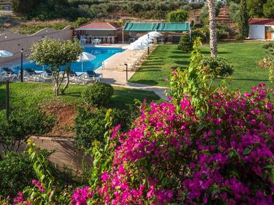 Verzorgde tuin met kleurrijke bloemen en zwembad in een hotelresort.