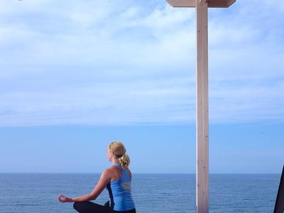 Moderne hotelbar met twee witte barkrukken en zeezicht via grote ramen
