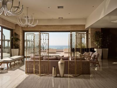 Modern hotelkamer met uitzicht op zee door grote open ramen.