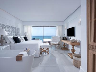 Moderne hotel eetzaal met witte tafelkleden, beklede stoelen en gestreepte vloertegels.