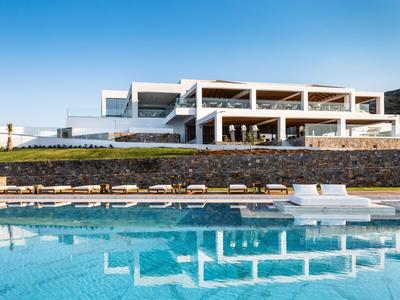 Modernes Hotel mit großem Pool und Liegestühlen bei klarem Himmel
