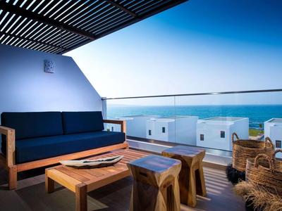 Moderner Balkon mit Holzmöbeln und Meerblick unter klarem blauem Himmel