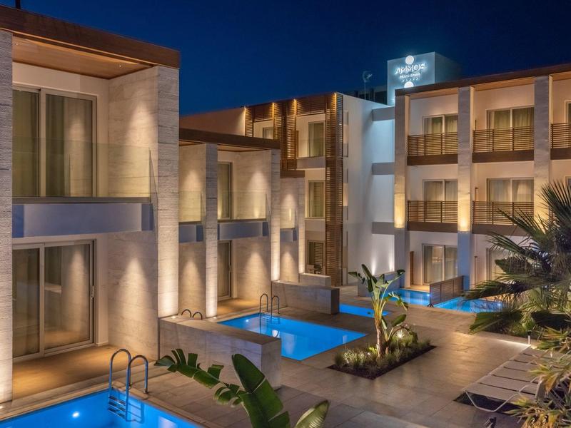 Modern hotel 's nachts met verlicht zwembad en gezellige kamers.