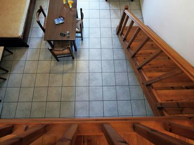 Blick von oben auf einen Essbereich mit Tisch, Stühlen und einer Holzbank an der Wand.