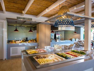 Buffet moderno con pasticceria, verdure e lampade sospese decorative.