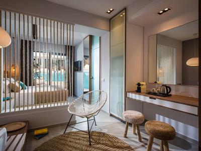 Camera d'hotel moderna con arredi in legno chiaro e design minimalista.