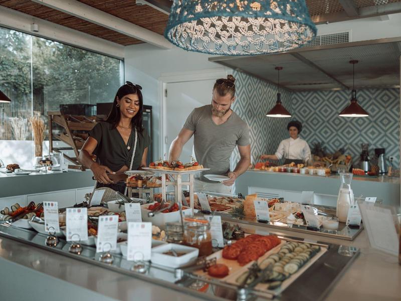 Buffet assortito con pasticceria, frutta e dessert in un hotel moderno.