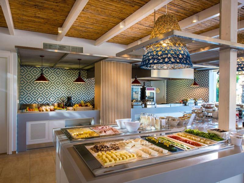 Buffet di colazione con espositori di dolci e verdure, arredamento caldo in legno.