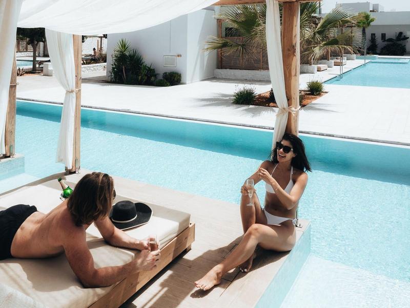 Due donne si rilassano vicino a una piscina in un ambiente alberghiero.