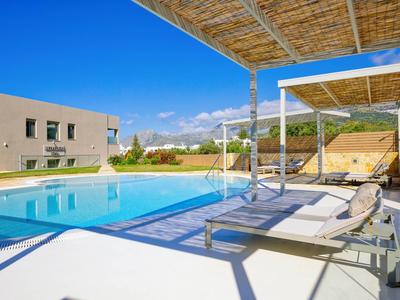 Area piscina moderna con lettini e tende parasole in una sistemazione soleggiata