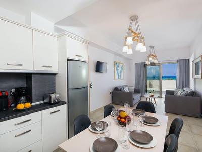 Světelná moderní kuchyně a jídelní prostor s výhledem na moře a balkon v apartmánu.