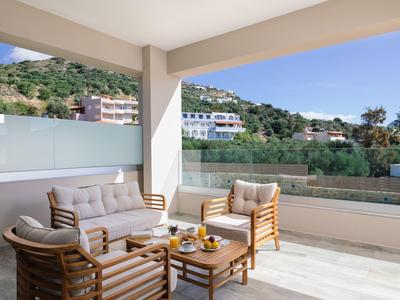 Terasa s moderním ratanovým posezením a výhledem na hory za jasné oblohy.