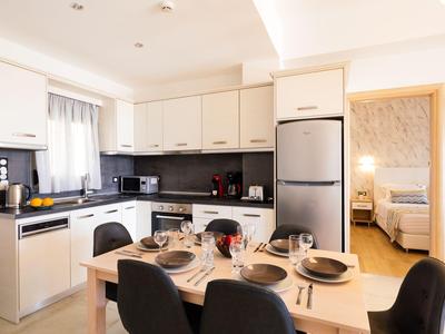 Cucina aperta moderna con zona pranzo e vista su una camera da letto.