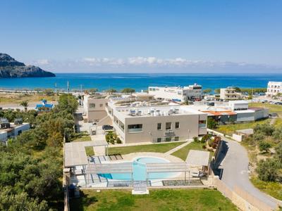 Pohled na hotel s bazénem u modrého moře a jasné oblohy poblíž pobřeží