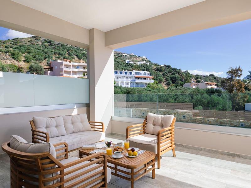 Terasa s moderním ratanovým posezením a výhledem na hory za jasné oblohy.