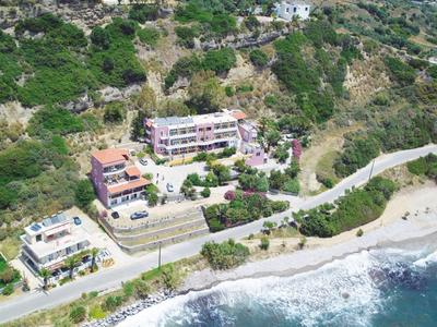 Plusieurs bâtiments le long d'une côte avec vue sur une plage et la mer.