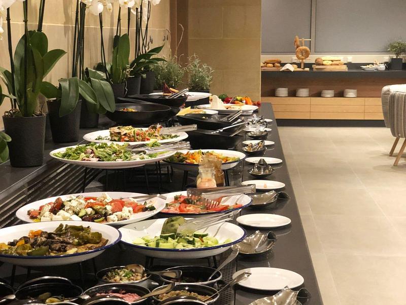 Bufet z różnymi potrawami i orchideami w nowoczesnej jadalni.