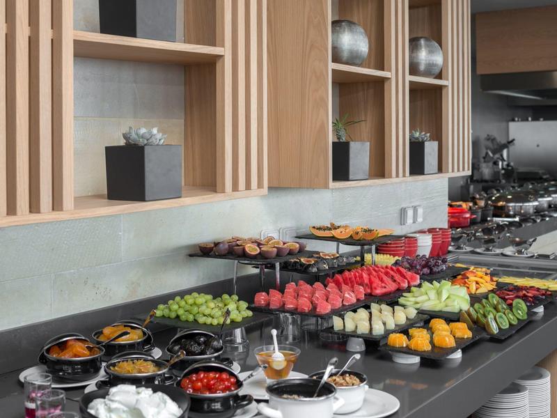 Różnorodne bufet z owocami, deserami i ciastkami na nowoczesnym stole w hotelu.