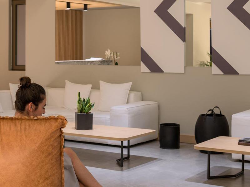 Nowoczesny salon z wygodnymi fotelami i dekoracyjnymi obrazami na ścianach.