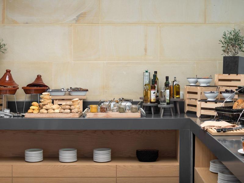 Bufet z chlebem, masłem, dżemem i napojami w nowoczesnej restauracji hotelowej.