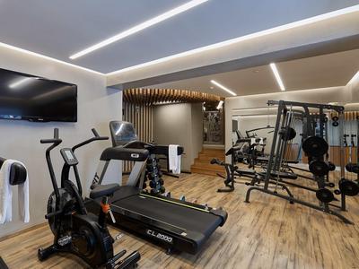 Palestra moderna con tapis roulant, cyclette e attrezzi per la forza, luminosa e spaziosa.