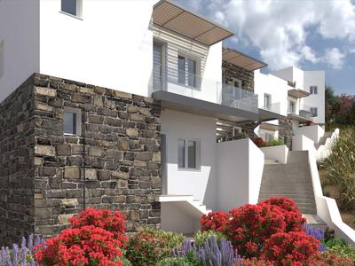 Complesso di edifici bianchi moderni con facciata in pietra e fiori colorati in primo piano.