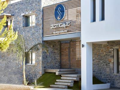 Ingresso moderno dell'edificio con rivestimento in legno e facciata in pietra, verde con piante