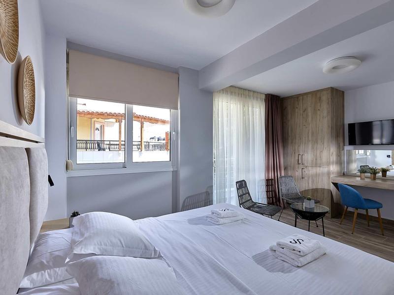 Nowoczesny pokój hotelowy z podwójnym łóżkiem, oknem, biurkiem i telewizorem