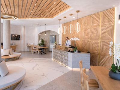 Moderner Empfang mit Holzdecke, geometrischer Wand, rundem Sofa und hellem Marmorboden.