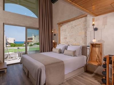 Schickes Schlafzimmer mit großem Bett, Holzdecke, Steinwand und Blick auf Garten mit Pool.