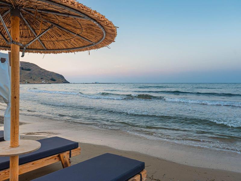 Plaża z leżakami i parasolem przy spokojnym morzu i czystym niebie