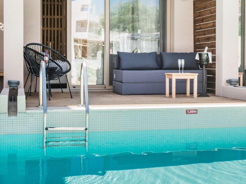 Nowoczesny teren na zewnątrz z basenem, drabinką i meblami na tarasie w świetle dziennym.