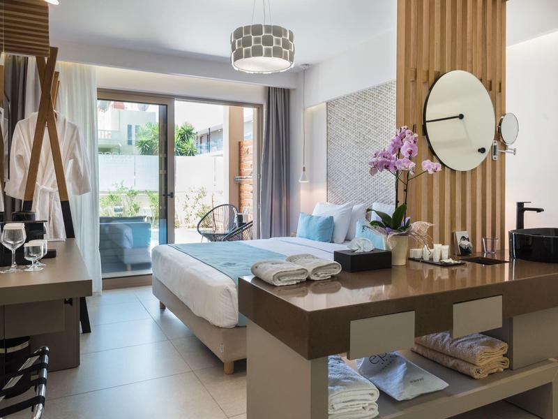 Nowoczesny pokój hotelowy z podwójnym łóżkiem, balkonem i stylowym wystrojem w jasnych tonach.