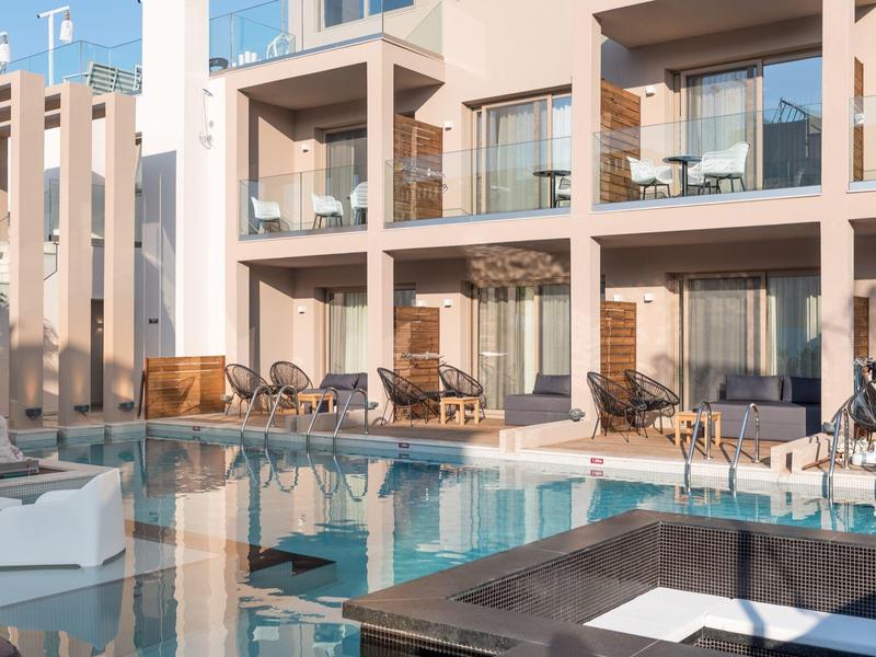 Nowoczesny basen hotelowy z leżakami i balkonami o zachodzie słońca