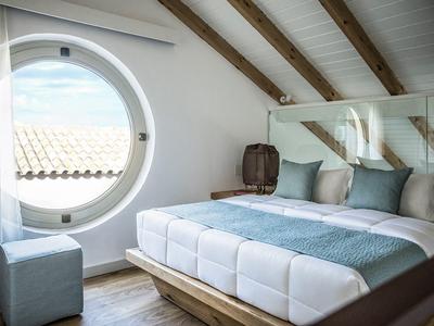 Camera accogliente con finestra rotonda e arredamento moderno.