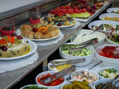 Buffet with various salads, fruits, and cold dishes in bowls and plates