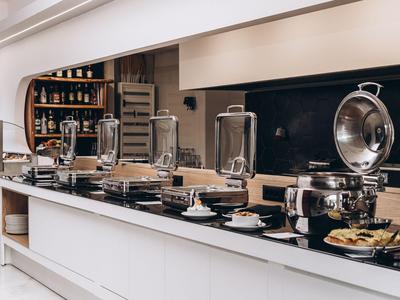 Bufé con platos calientes y tapas en un restaurante moderno.