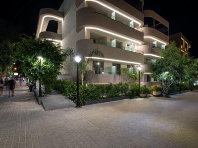 Edificio moderno di un hotel con balconi illuminati e alberi di notte