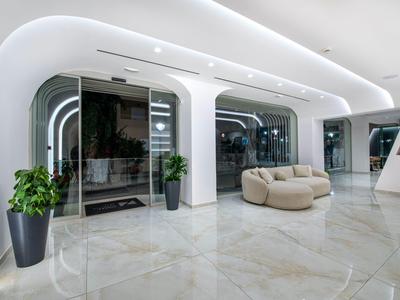 Moderno vestíbulo de hotel con asientos cómodos, grandes ventanas y plantas.