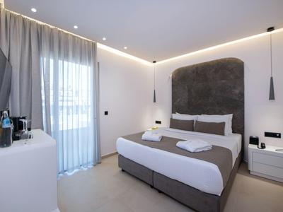 Modern bedroom with double bed, sideboards, and large windows with curtains.