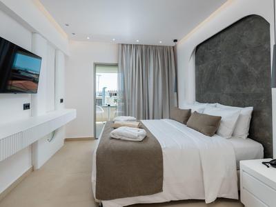Modern hotel room with double bed, bright interior, and balcony view